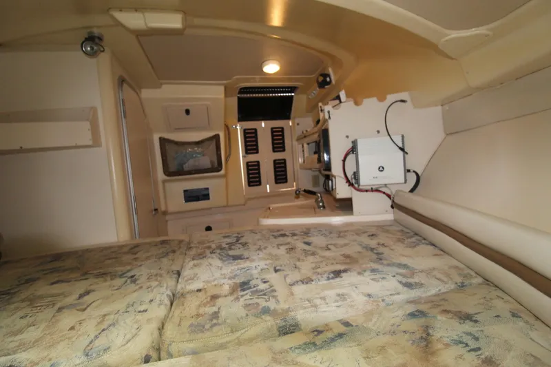 Slide: The Image of 2002 Grady-White Express 265 cabin interior with bed, storage, and electronics. - 19