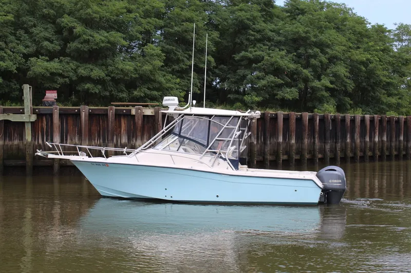 Slide: The Image of 2002 Grady-White Express 265 boat on calm water near a wooden dock. - 2
