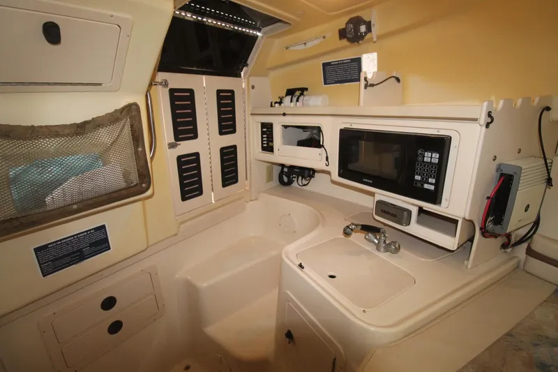 Slide: The Image of 2002 Grady-White Express 265 cabin interior with kitchenette and storage compartments. - 20