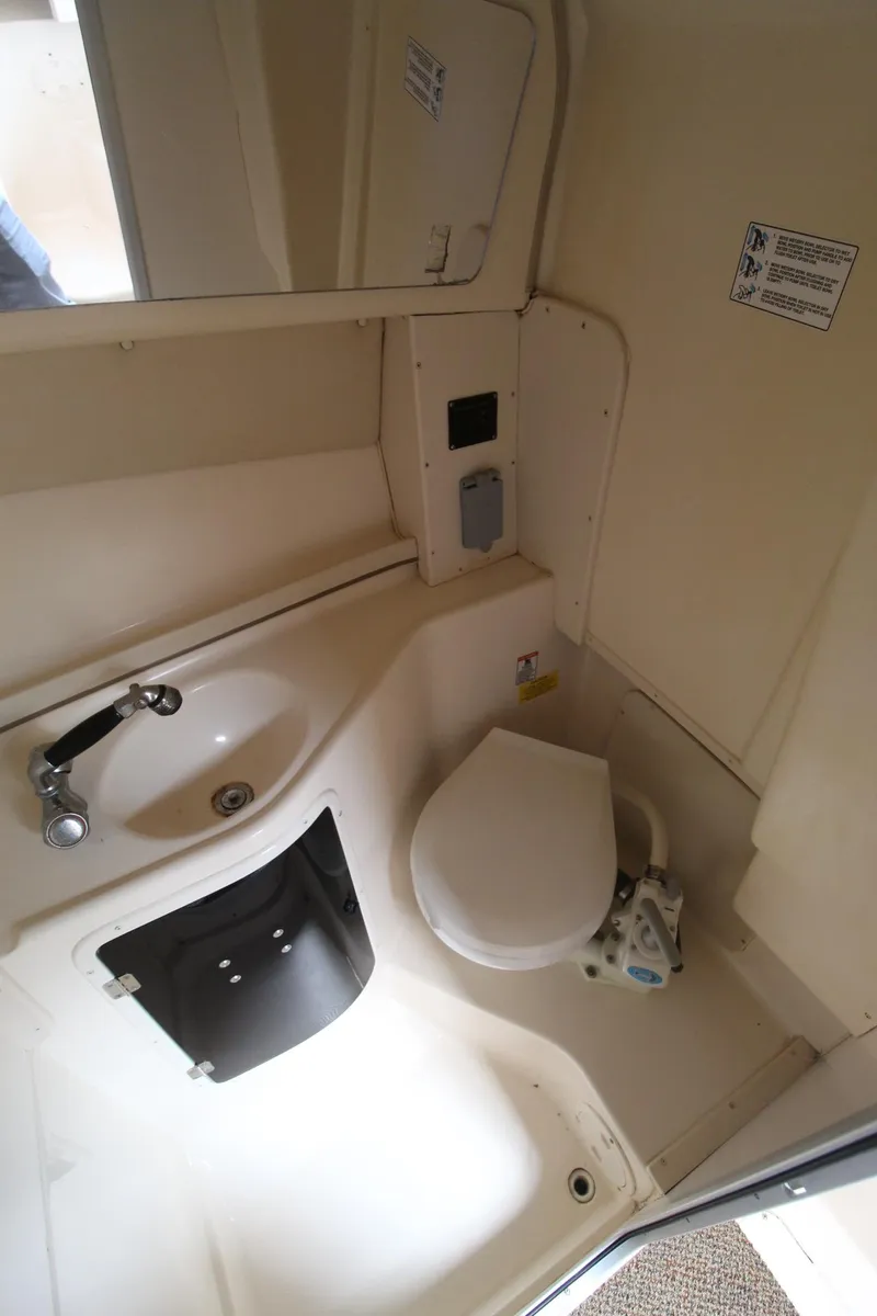 Slide: The Image of 2002 Grady-White Express 265 boat bathroom with sink, toilet, and mirror. - 21