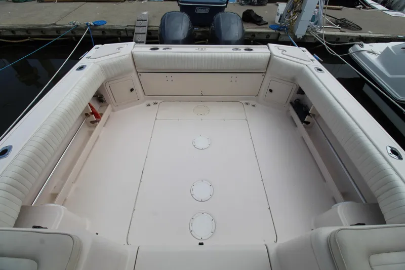 Slide: The Image of 2002 Grady-White Express 265 boat deck with cushioned seating and storage compartments. - 26