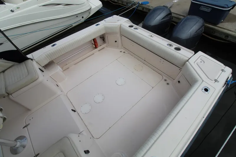 Slide: The Image of 2002 Grady-White Express 265 boat deck with seating and twin outboard motors. - 28