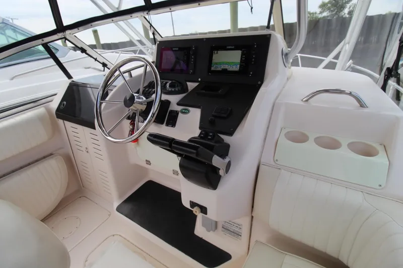 Slide: The Image of 2002 Grady-White Express 265 helm with steering wheel, controls, and navigation screens. - 7