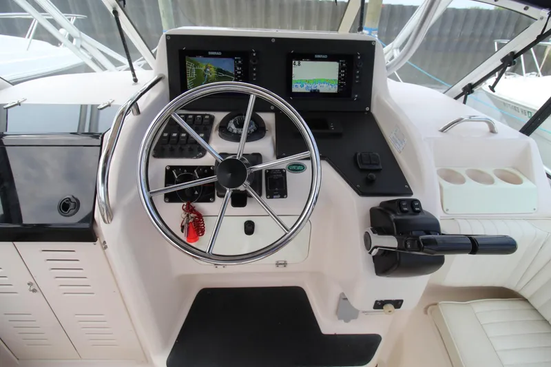 Slide: The Image of 2002 Grady-White Express 265 helm with steering wheel, controls, and navigation screens. - 8