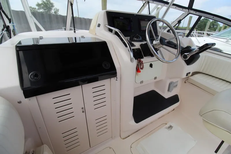 Slide: The Image of 2002 Grady-White Express 265 boat helm with steering wheel and control panel. - 9