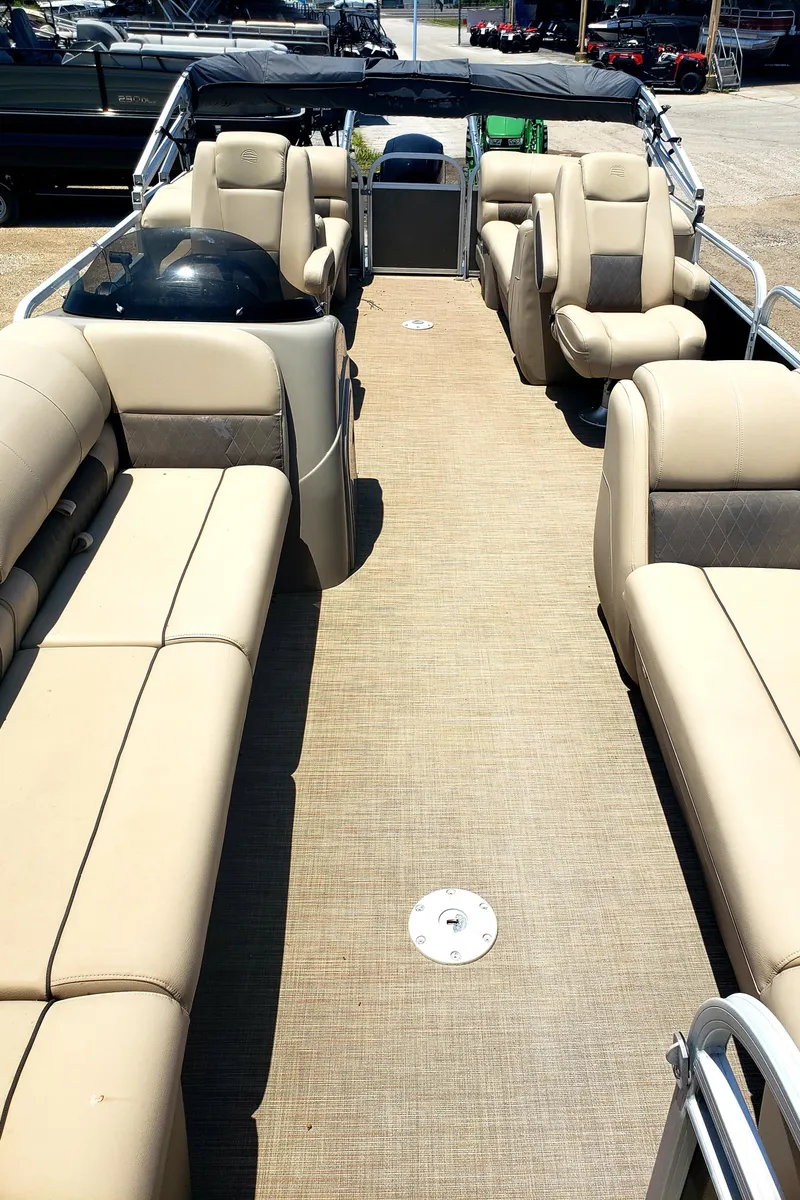 Slide: The Image of 2021 Sun Tracker Party Barge 24 interior with beige seating and spacious layout. - 2