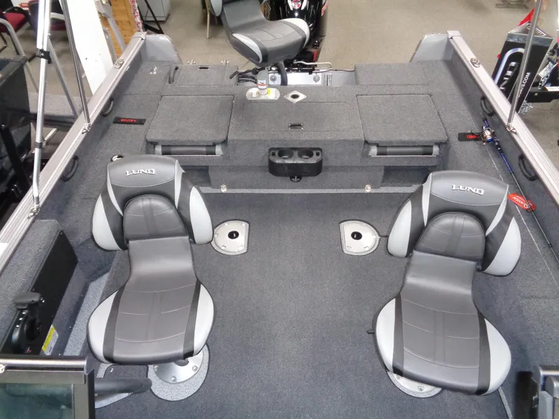Slide: The Image of 2024 Lund 1775 Impact XS boat interior with two gray seats and storage compartments. - 24