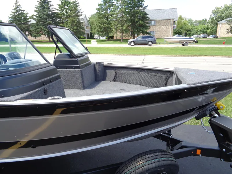 Slide: The Image of 2024 Lund 1775 Impact XS fishing boat on trailer, parked in residential area. - 6