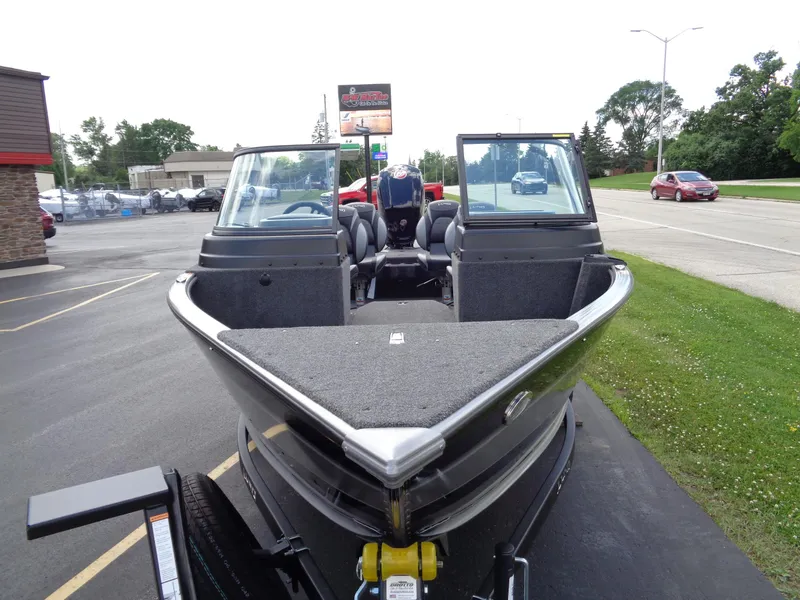 Slide: The Image of 2024 Lund 1775 Impact XS fishing boat on display in a parking lot. - 7