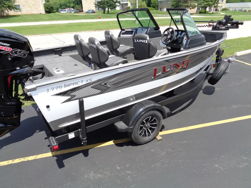 Slide: The Image of 2024 Lund 1775 Impact XS fishing boat on trailer in parking lot. - 4