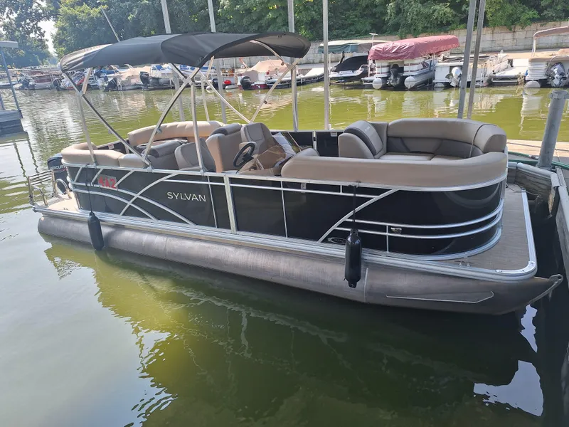 The Image of 2025 Sylvan Mirage 822 LZ pontoon boat docked on calm water. - 0