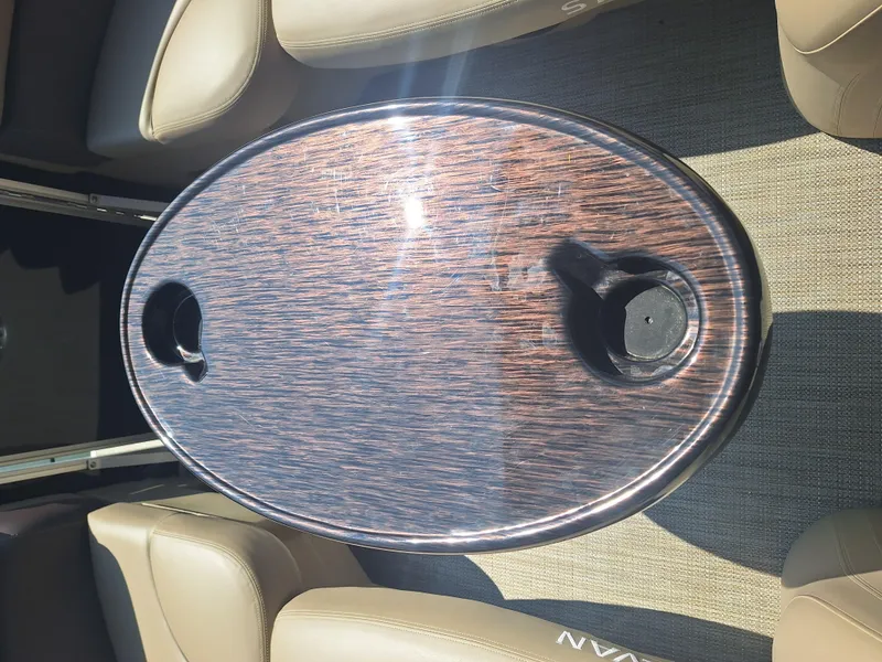 Slide: The Image of Oval table on Sylvan Mirage 822 LZ boat, 2025 model, with cup holders and beige seating. - 12