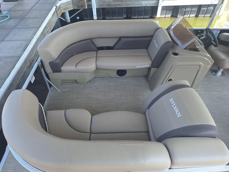 Slide: The Image of 2025 Sylvan Mirage 822 LZ pontoon boat interior with beige seating and carpeted floor. - 23