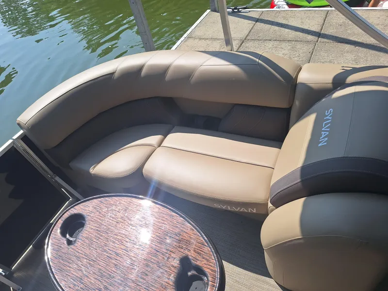 Slide: The Image of Luxurious seating on 2025 Sylvan Mirage 822 LZ pontoon boat by the water. - 5
