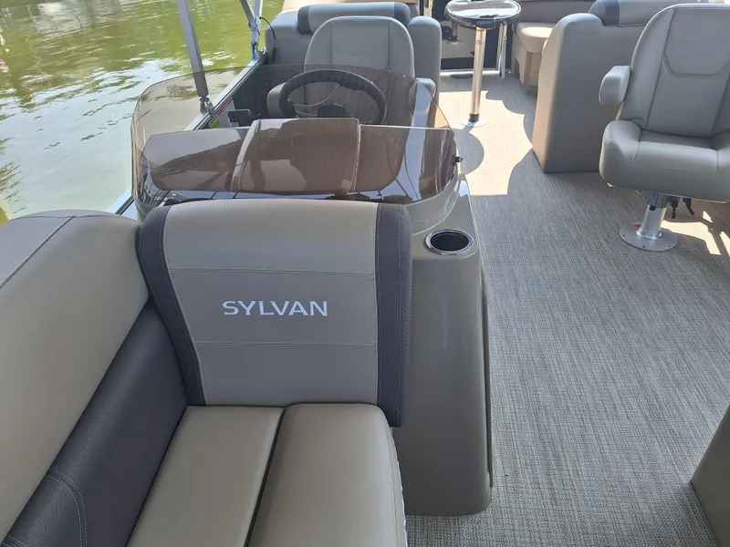 Slide: The Image of 2025 Sylvan Mirage 822 LZ pontoon boat interior with plush seating and steering console. - 8