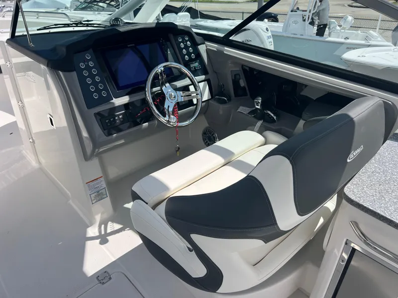 Slide: The Image of 2024 Robalo R317 Dual Console boat cockpit with modern controls and comfortable seating. - 13