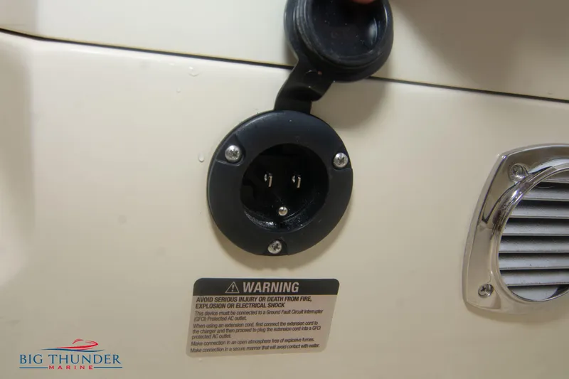 Slide: The Image of 2024 Invictus TT280S power socket and warning label on boat exterior. - 10