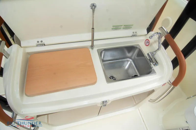 Slide: The Image of Compact kitchenette with sink and cutting board on 2024 Invictus TT280S boat. - 11