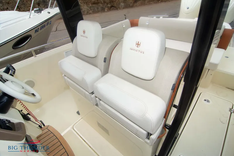 Slide: The Image of 2024 Invictus TT280S boat interior with white leather seats and steering wheel. - 27