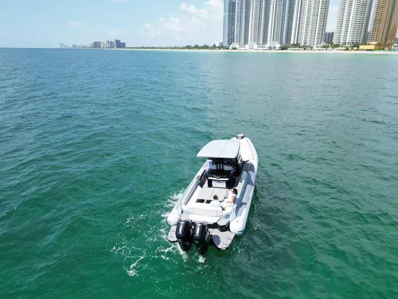 Slide: The Image of 2025 Ranieri CAYMAN 38.0 EXECUTIVE boat cruising near a coastal city skyline. - 4