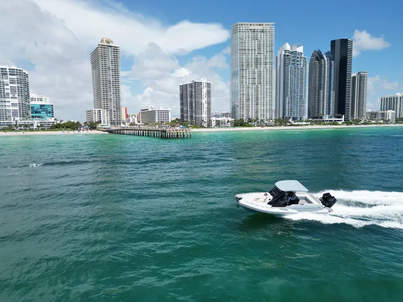 Slide: The Image of Ranieri CAYMAN 38.0 EXECUTIVE 2025 boat cruising near a city skyline and beach. - 6