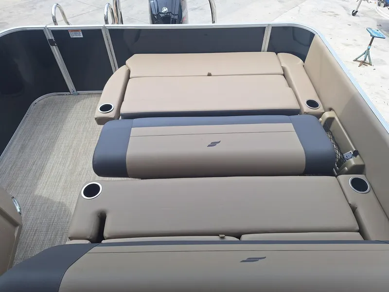 Slide: The Image of 2024 Starcraft EX 22 Weekender boat interior with beige seating and cup holders. - 13