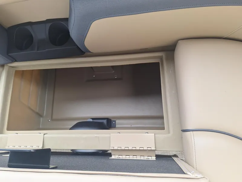 Slide: The Image of 2024 Starcraft EX 22 Weekender storage compartment with beige interior and cup holders. - 20