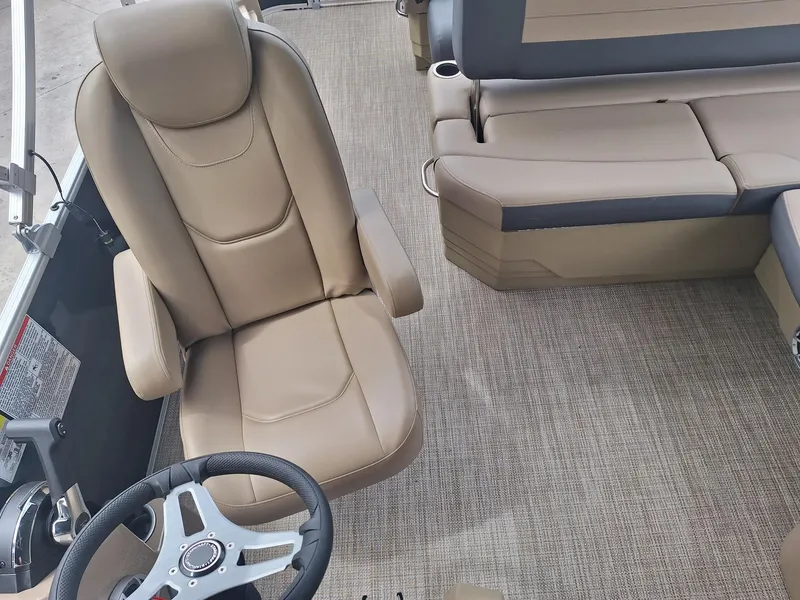 Slide: The Image of 2024 Starcraft EX 22 Weekender boat interior with beige seating and steering wheel. - 23