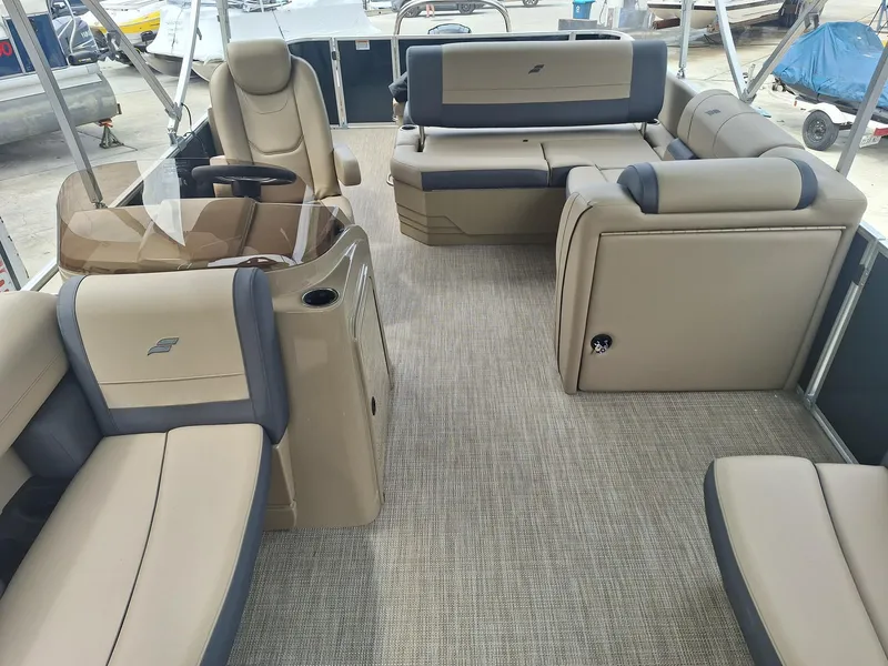 Slide: The Image of 2024 Starcraft EX 22 Weekender boat interior with beige seating and carpeted flooring. - 6