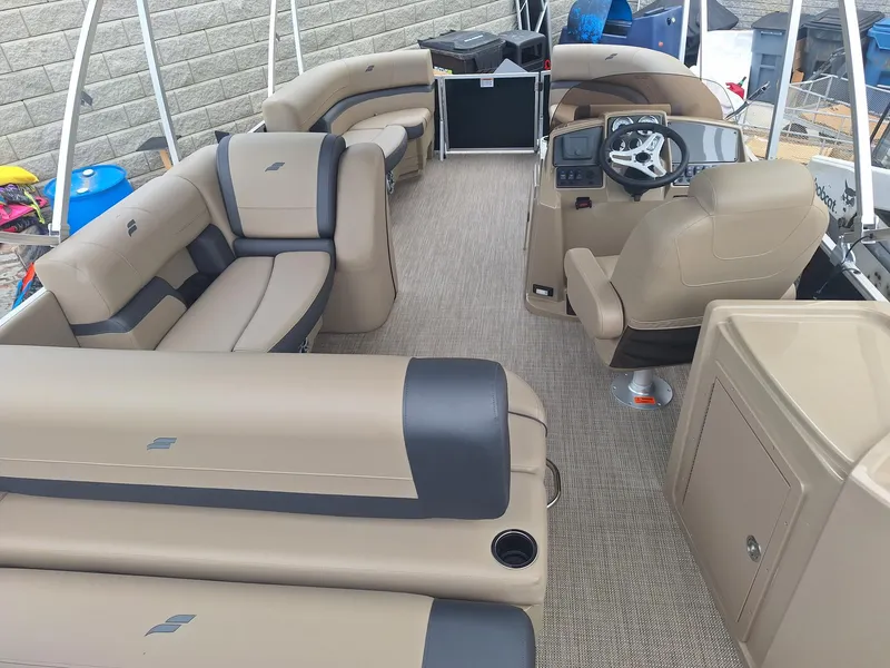 Slide: The Image of 2024 Starcraft EX 22 Weekender boat interior with beige seating and modern helm. - 7