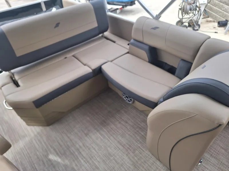 Slide: The Image of 2024 Starcraft EX 22 Weekender boat interior with beige and gray seating. - 9