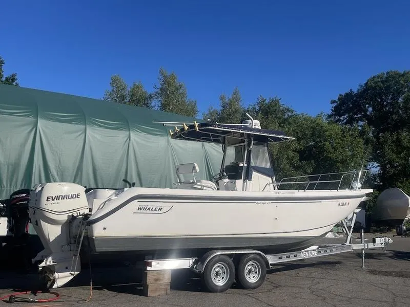Slide: The Image of 2000 Boston Whaler 260 Outrage boat on trailer, parked outdoors. - 1