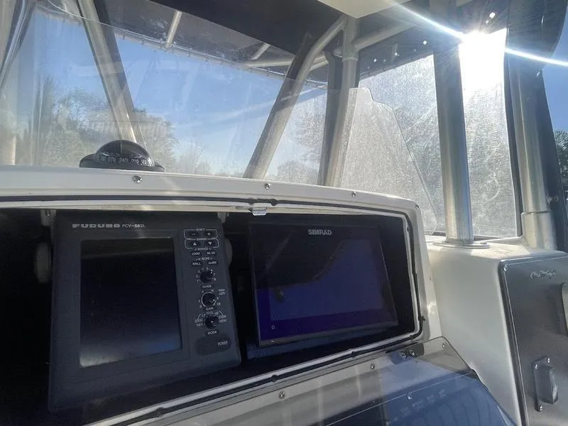 Slide: The Image of Boston Whaler 260 Outrage 2000 dashboard with navigation screens and controls. - 9