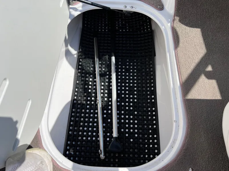 Slide: The Image of Storage compartment of a 2008 Four Winns H200 boat with black mat and metal rods. - 15