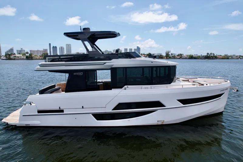 Slide: The Image of 2022 OKEAN Flybridge 50 yacht on water with city skyline background. - 1