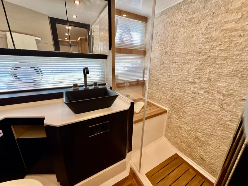 Slide: The Image of Modern bathroom on 2022 OKEAN Flybridge 50 yacht with sleek black sink and textured wall. - 19