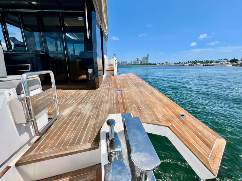 Slide: The Image of OKEAN Flybridge 50 2022 yacht with wooden deck, docked by the water on a sunny day. - 44