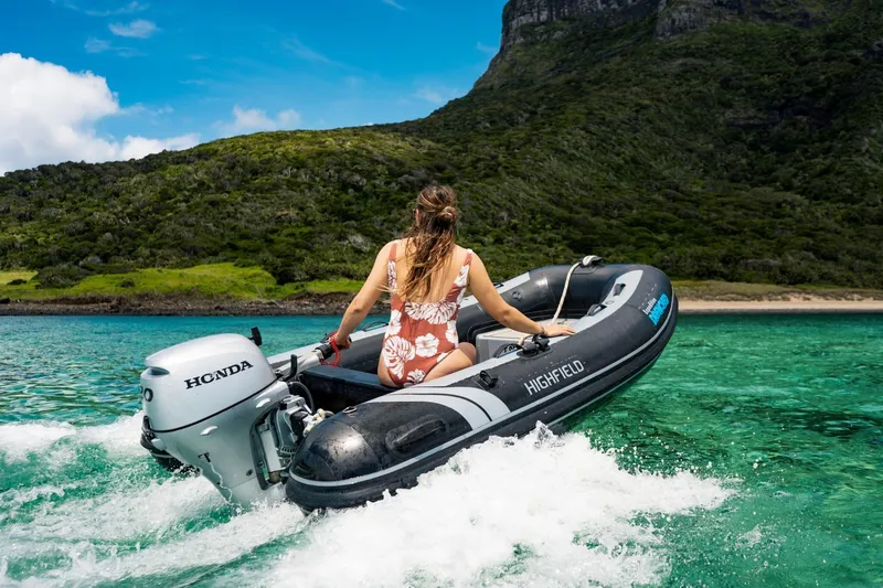 The Image of Woman driving 2026 Highfield Classic 290 boat on clear water. - 0