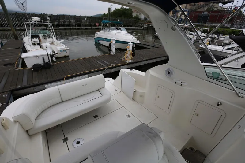 Slide: The Image of 2005 Cruisers Yachts 280 CXi Express at a marina, featuring spacious seating and docked boats. - 11