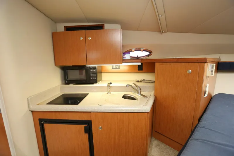 Slide: The Image of Compact kitchen area in 2005 Cruisers Yachts 280 CXi Express with microwave, sink, and stove. - 17