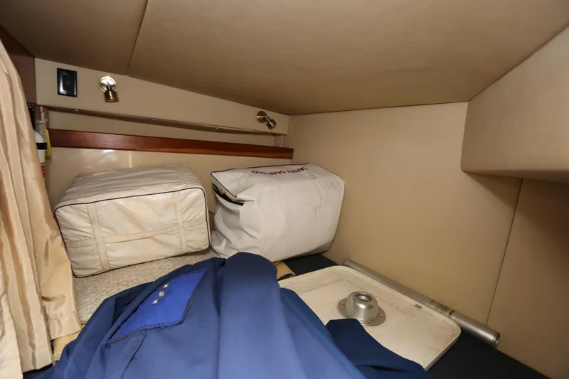 Slide: The Image of Interior storage area of 2005 Cruisers Yachts 280 CXi Express with bags and clothing. - 21