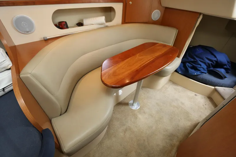 Slide: The Image of 2005 Cruisers Yachts 280 CXi Express cabin with beige seating and wooden table. - 16