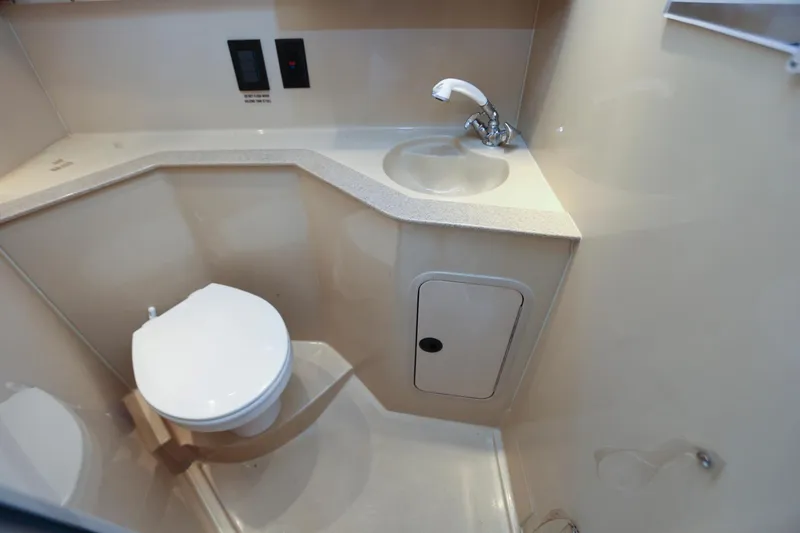 Slide: The Image of 2005 Cruisers Yachts 280 CXi Express bathroom with toilet, sink, and storage. - 22