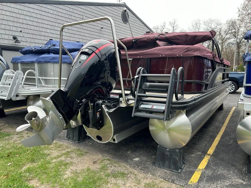 Slide: The Image of 2024 Bennington 22SSR pontoon boat with covered seating and outboard motor. - 3