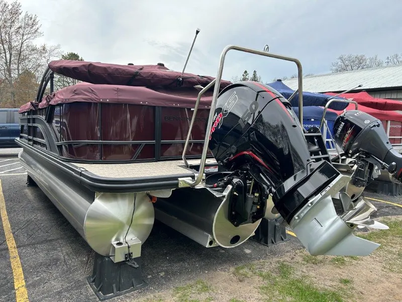 Slide: The Image of 2024 Bennington 22SSR pontoon boat with outboard motor, covered and parked outdoors. - 4