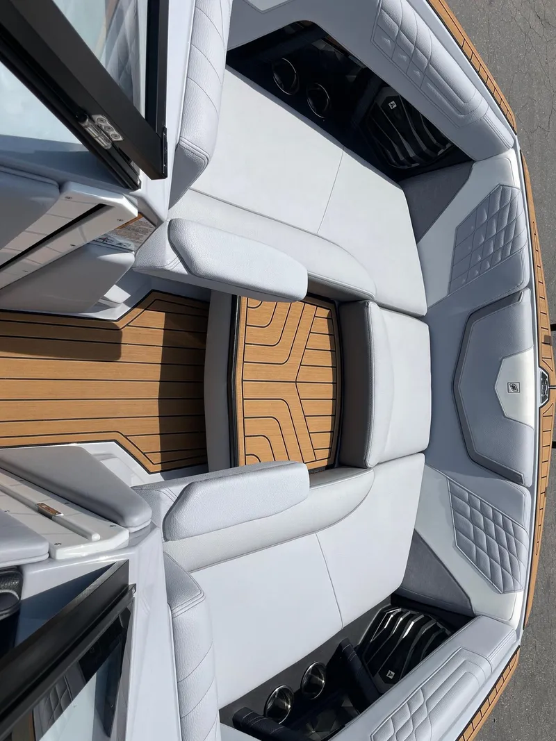 Slide: The Image of 2022 Nautique Super Air G23 boat interior with white seating and teak flooring. - 11