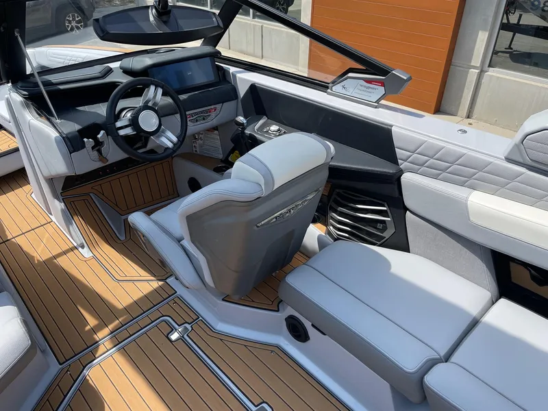 Slide: The Image of 2022 Nautique Super Air G23 boat interior with modern dashboard and luxurious seating. - 6