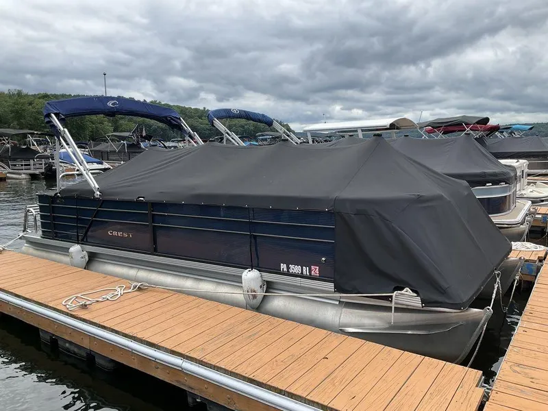 Slide: The Image of 2021 Crest Classic LX 240 L pontoon boat docked with black cover. - 4