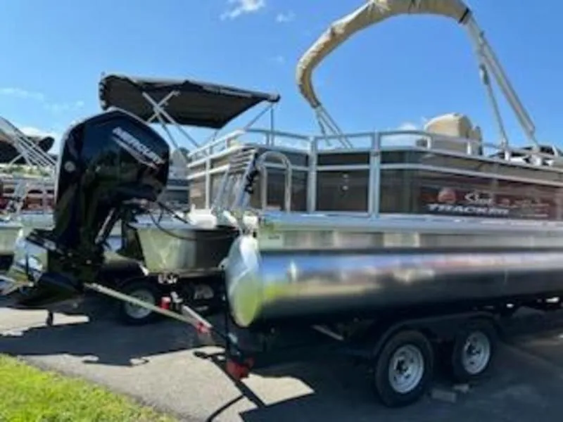Slide: The Image of 2024 Sun Tracker SF 20 DLX pontoon boat on trailer, parked outdoors. - 12