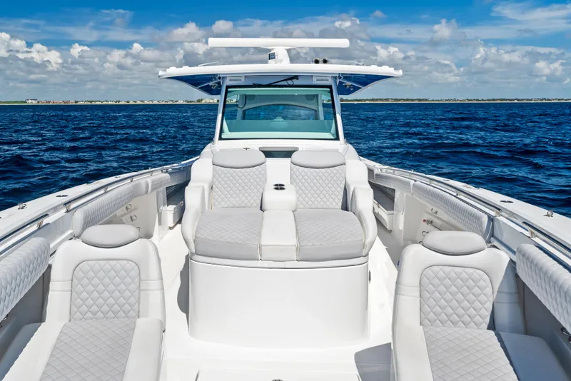 Slide: The Image of 2022 HCB Suenos boat with luxurious seating on open water under a clear sky. - 10